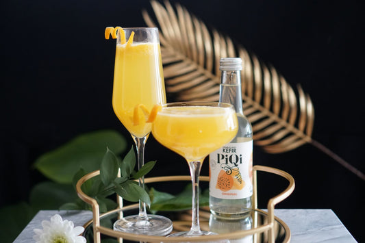 Features PiQi water kefir with two Mimosa mocktails in 2 different glasses